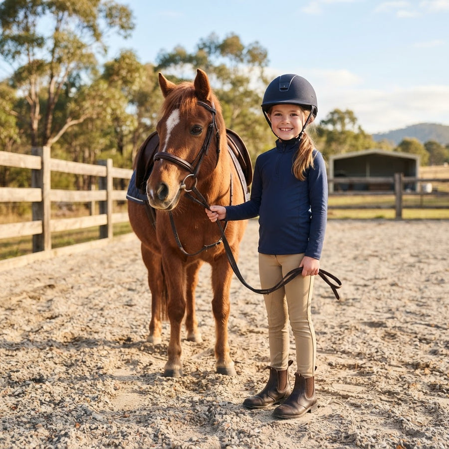 Child rider wearing kids equestrian clothing and riding helmet in Australia