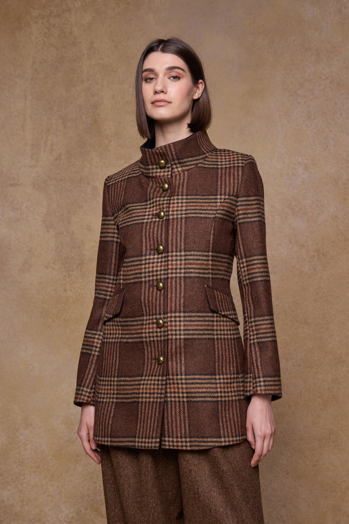 Woman wearing a brown tweed plaid coat against a beige background